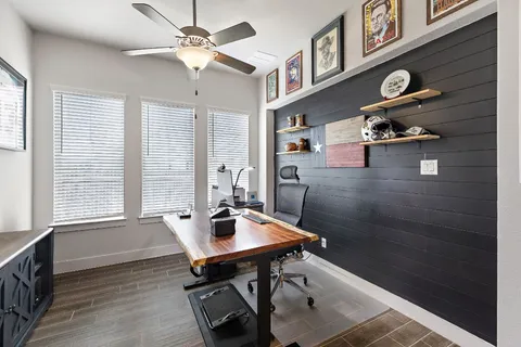 a view of a workspace with furniture and a window