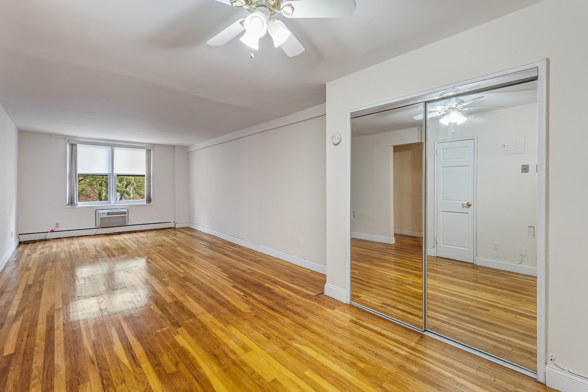 54-44 Little Neck Parkway, Unit 5G Queens, NY 11362 - Photo 5 of 20 wooden floor in an empty room with a window