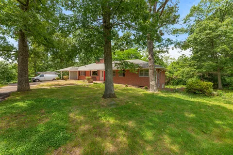 a view of a house with a backyard and a tree