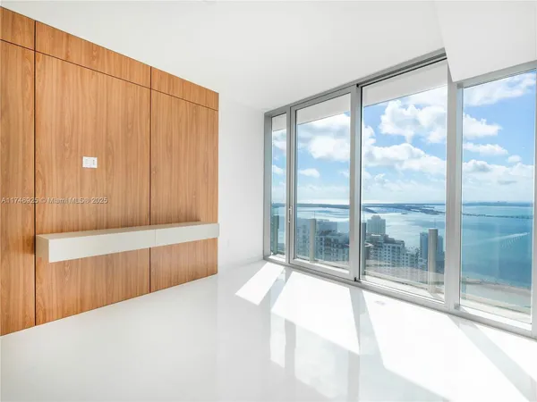 a spacious bedroom with a large window and a balcony