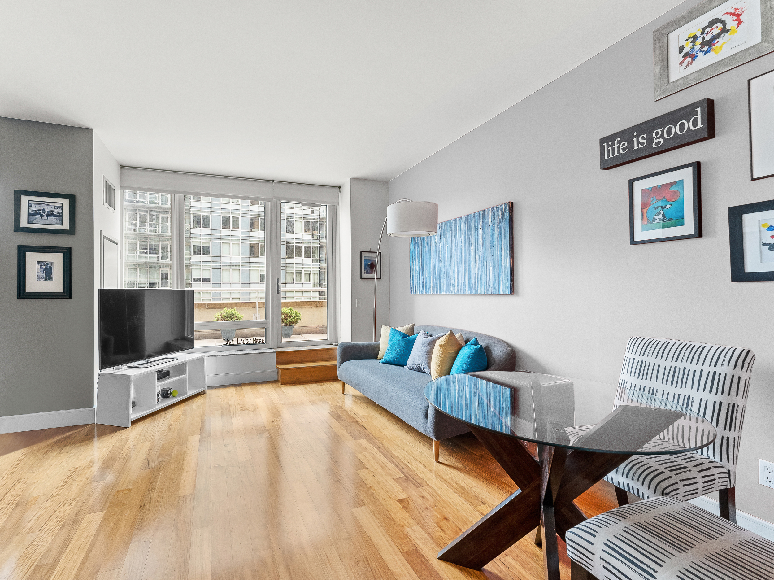 250 East 53rd Street, Unit 903 Manhattan, NY 10022 - Photo 3 of 8 a living room with furniture and a flat screen tv