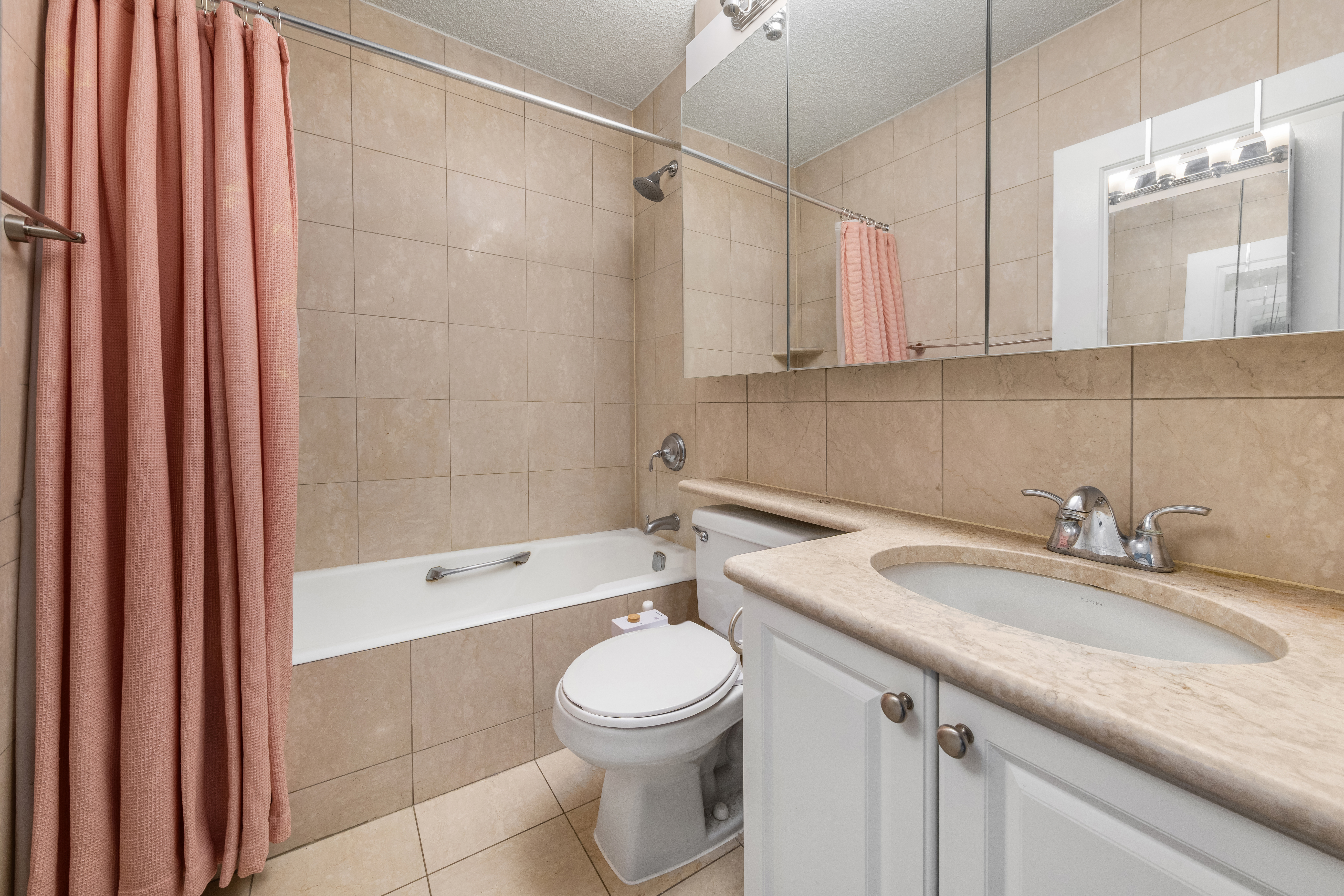 151-155 East 31st Street, Unit 12C Manhattan, NY 10016 - Photo 5 of 7 a bathroom with a granite countertop sink toilet a mirror and shower