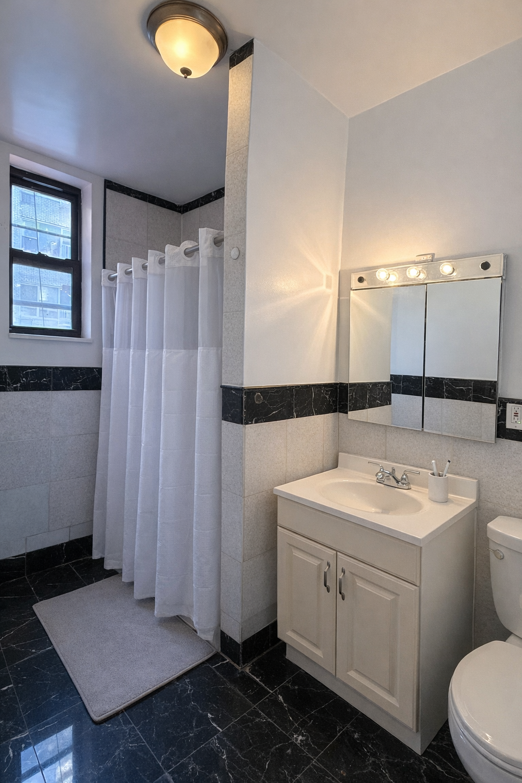 357 East 58th Street, Unit 2W Manhattan, NY 10022 - Photo 6 of 6 a bathroom with a sink toilet and shower