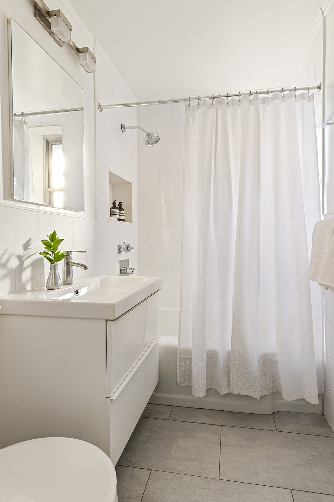 550 Grand Street, Unit G3E Manhattan, NY 10002 - Photo 6 of 7 a bathroom with a sink a toilet and shower