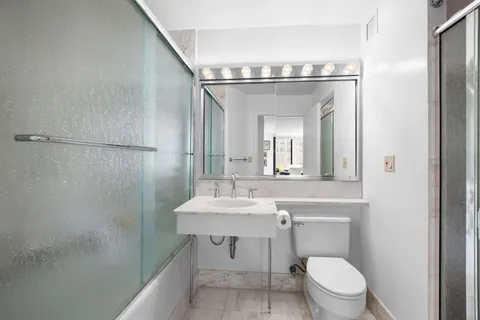 a bathroom with a toilet a sink and mirror