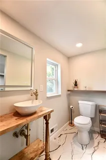 a bathroom with a toilet a sink and mirror