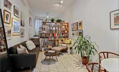 a living room with patio furniture and a potted plant
