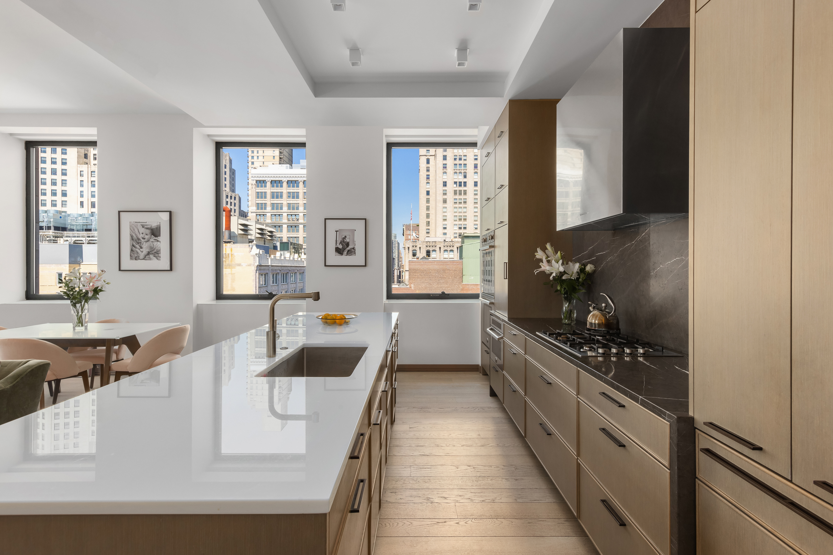 88 Lexington Avenue, Unit 1606 Manhattan, NY 10010 - Photo 7 of 20 a large white kitchen with granite countertop a stove a sink a dining table and chairs