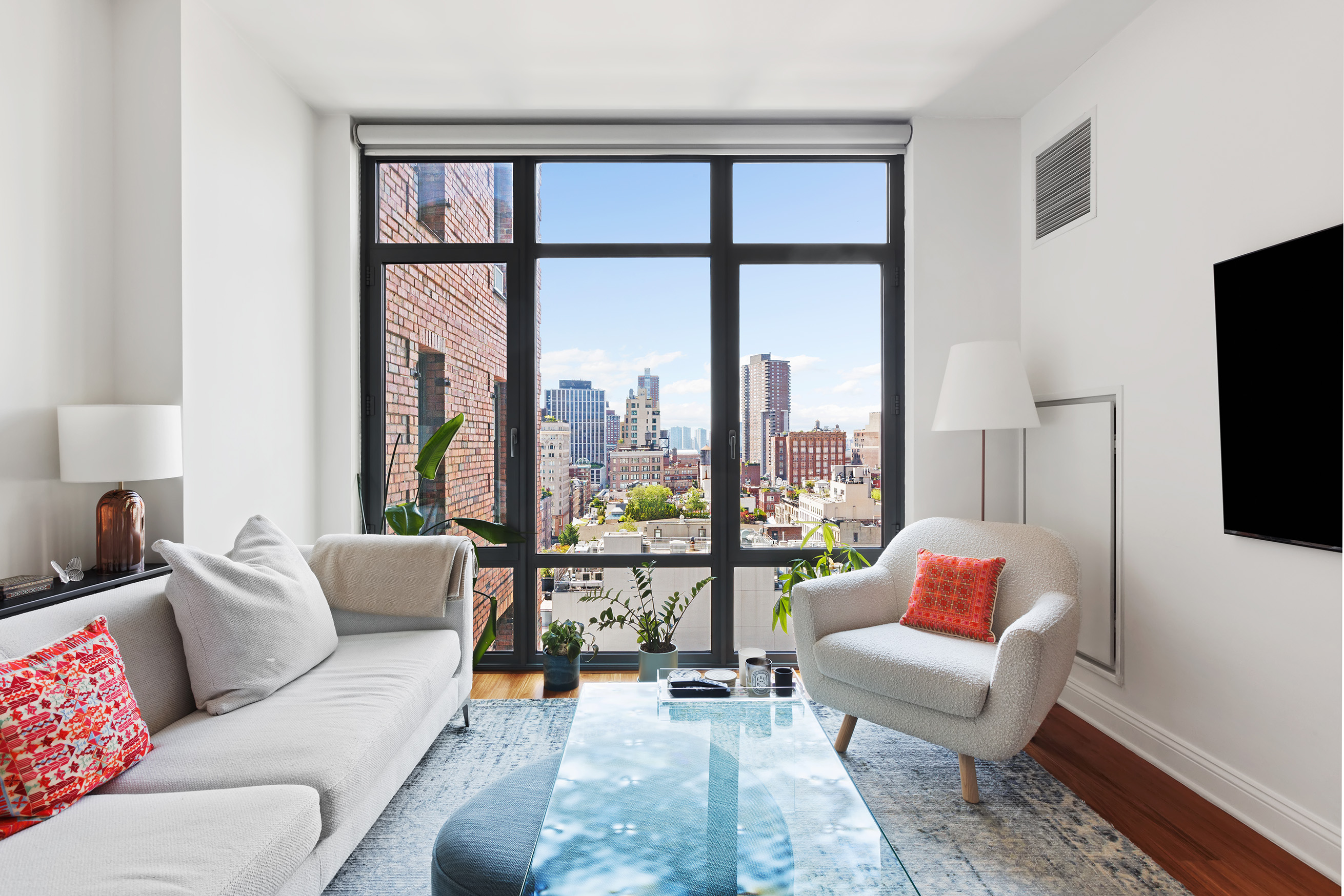 a living room with furniture and a floor to ceiling window