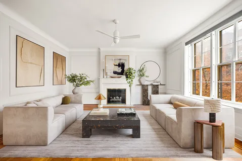 a living room with furniture a fireplace and a large window