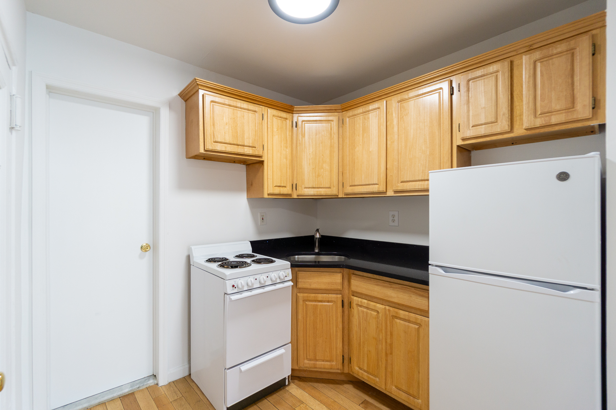 337 East 6th Street, Unit 9 Manhattan, NY 10003 - Photo 9 of 15 a kitchen with a refrigerator a stove cabinets and a window