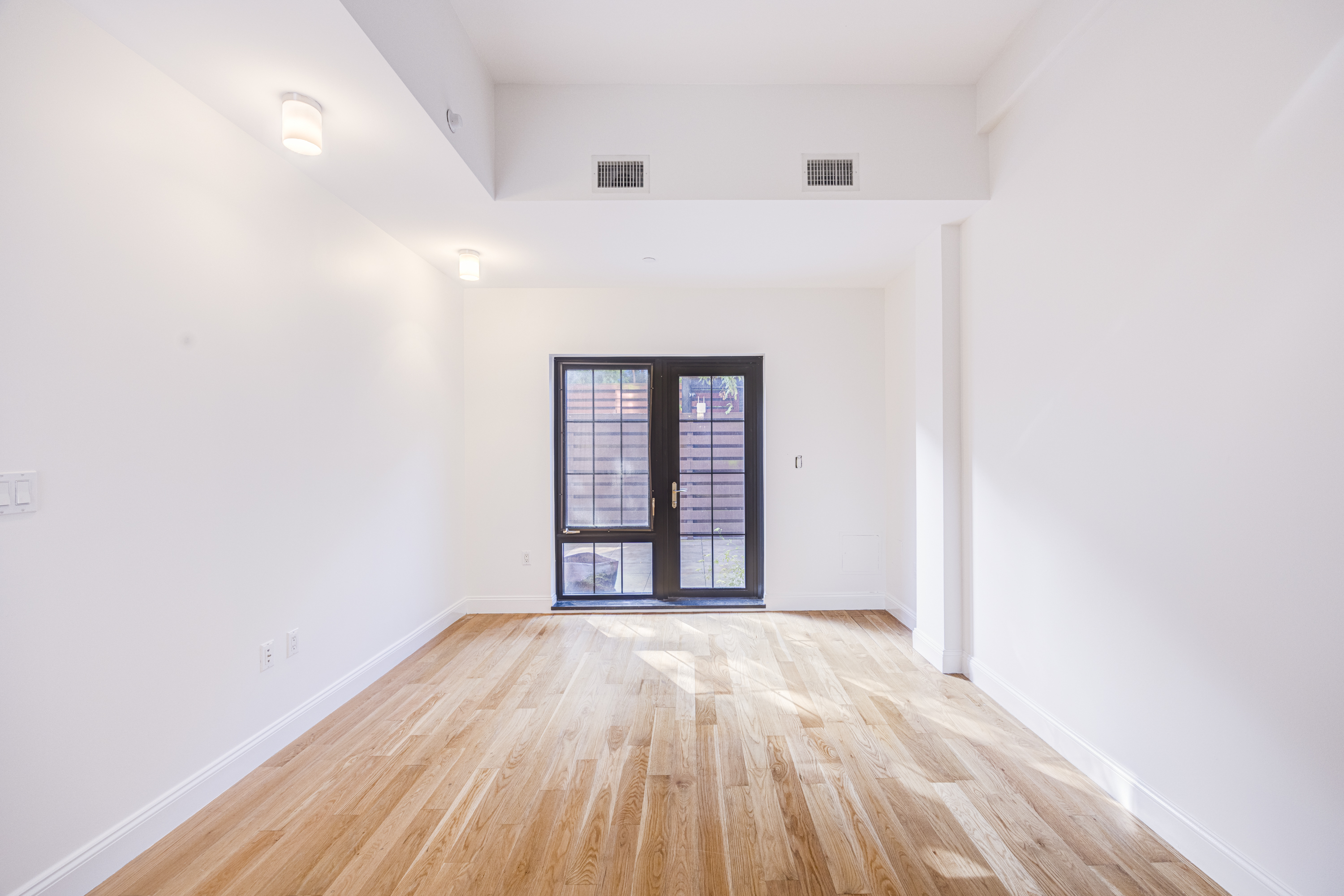 42 Maspeth Avenue, Unit 1D Brooklyn, NY 11211 - Photo 17 of 28 a view of an empty room with wooden floor and a window