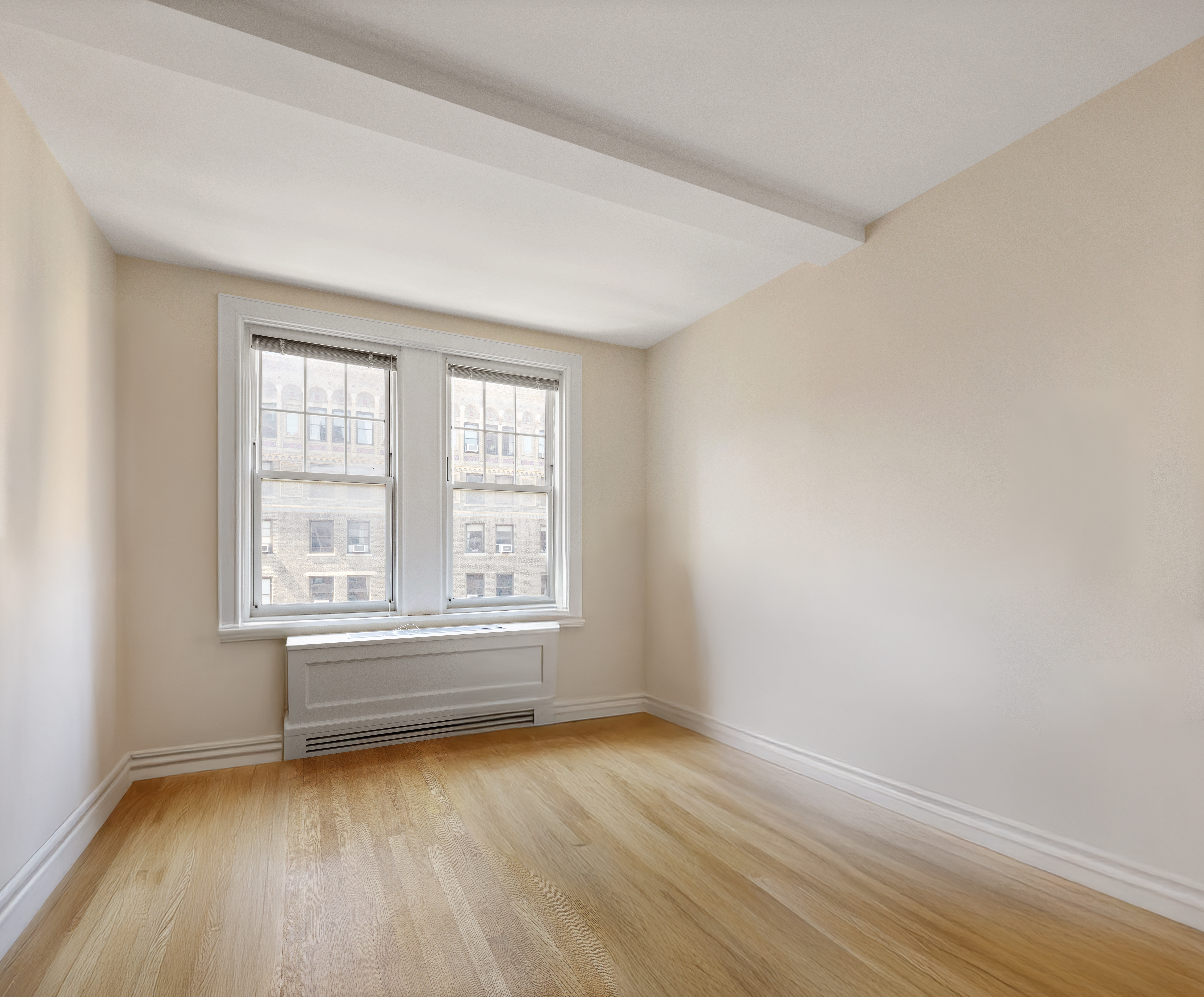 27 West 72nd Street, Unit 1403 Manhattan, NY 10023 - Photo 9 of 18 an empty room with wooden floor and windows