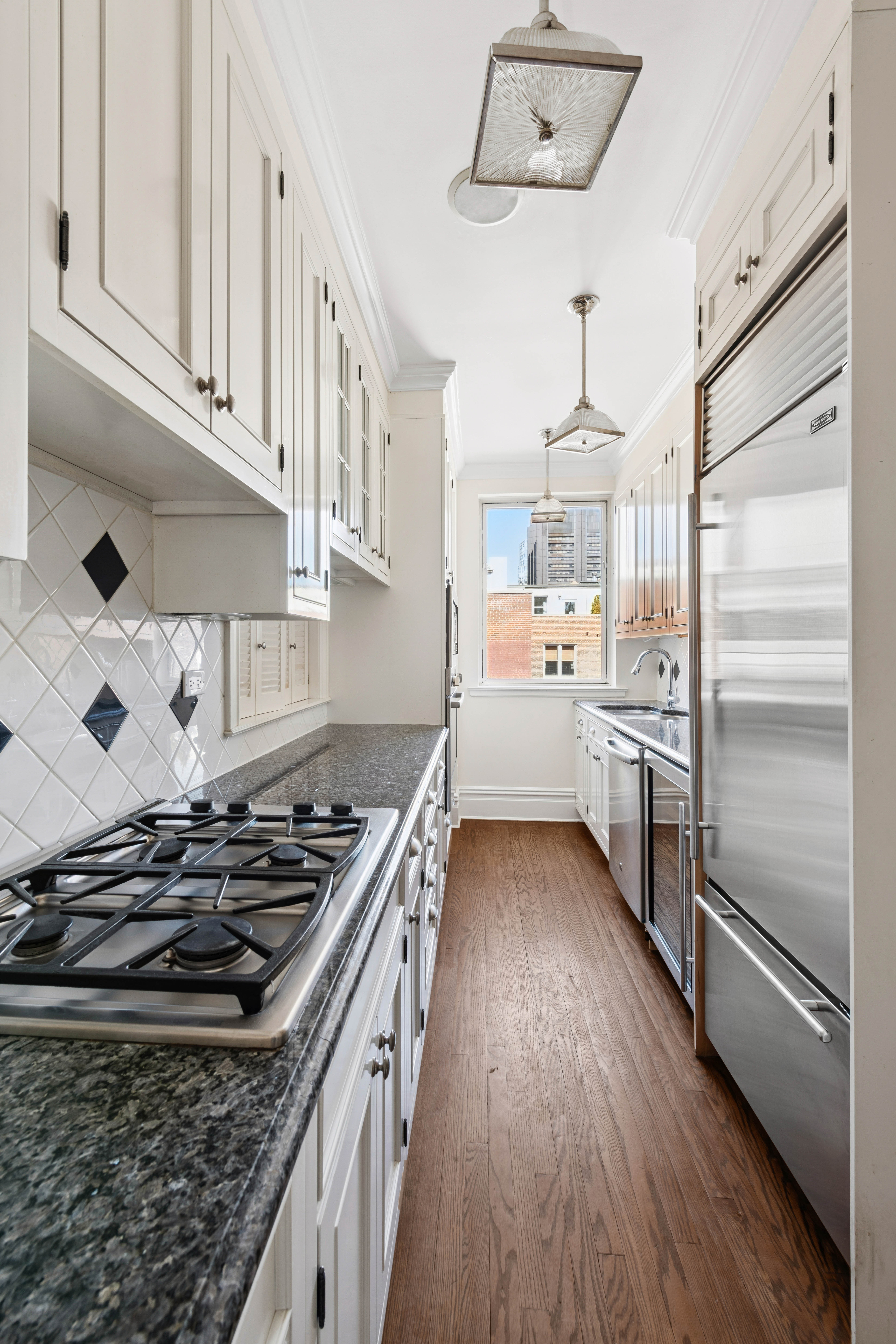 1140 5th Avenue, Unit 14B Manhattan, NY 10128 - Photo 5 of 18 a kitchen with a stove and a refrigerator