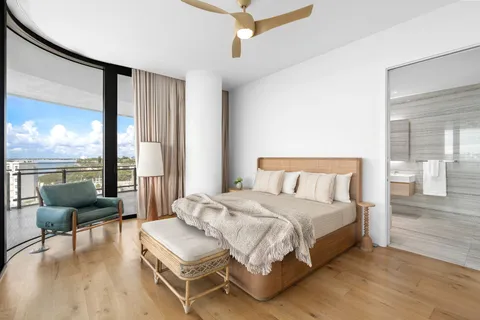 a bedroom with a bed and large windows