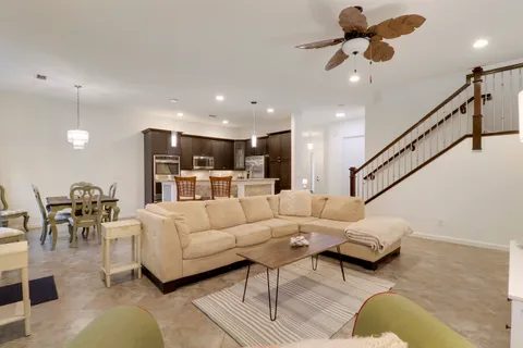 a living room with furniture kitchen view and a chandelier