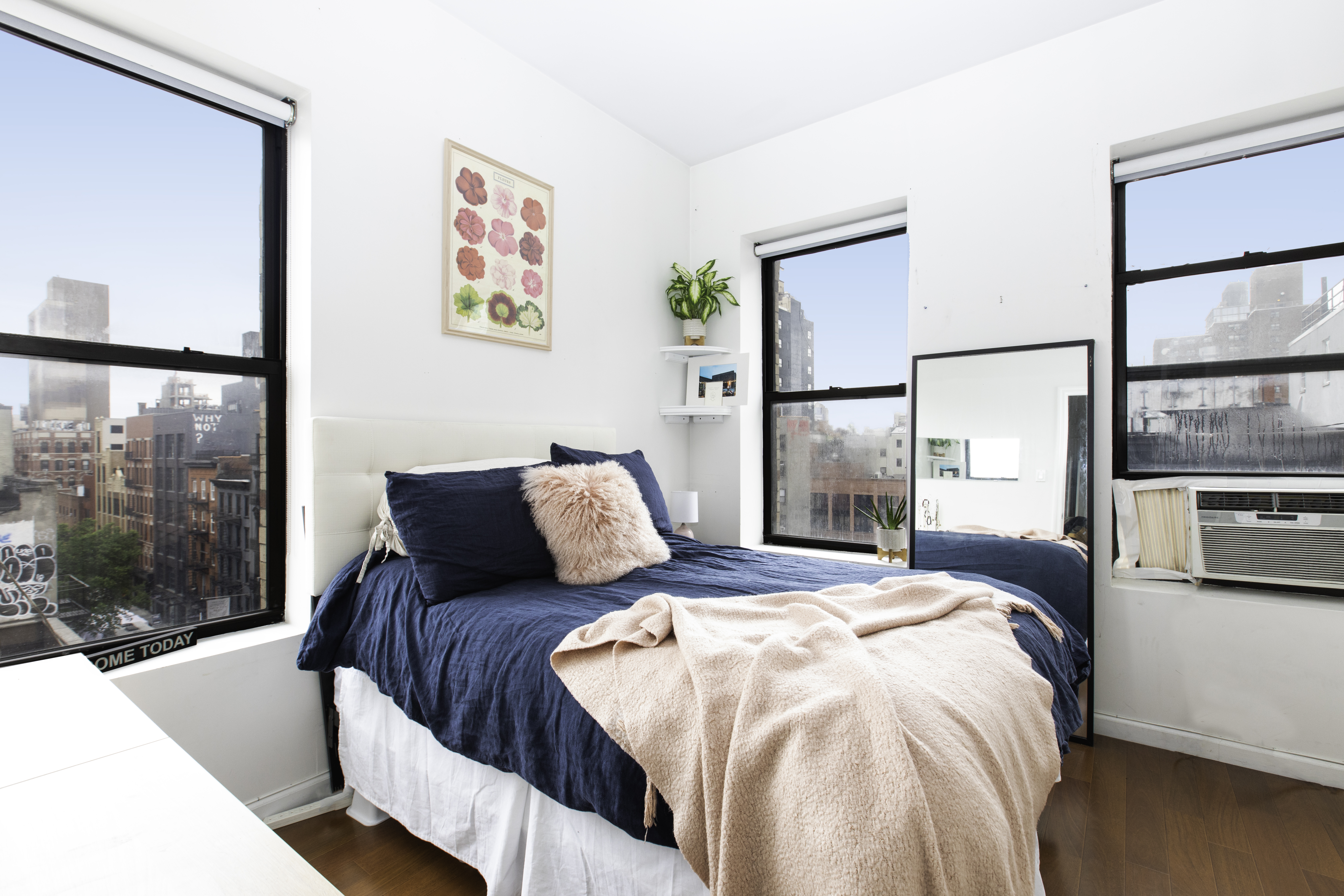 a bedroom with a balcony a bed and a painting on the wall