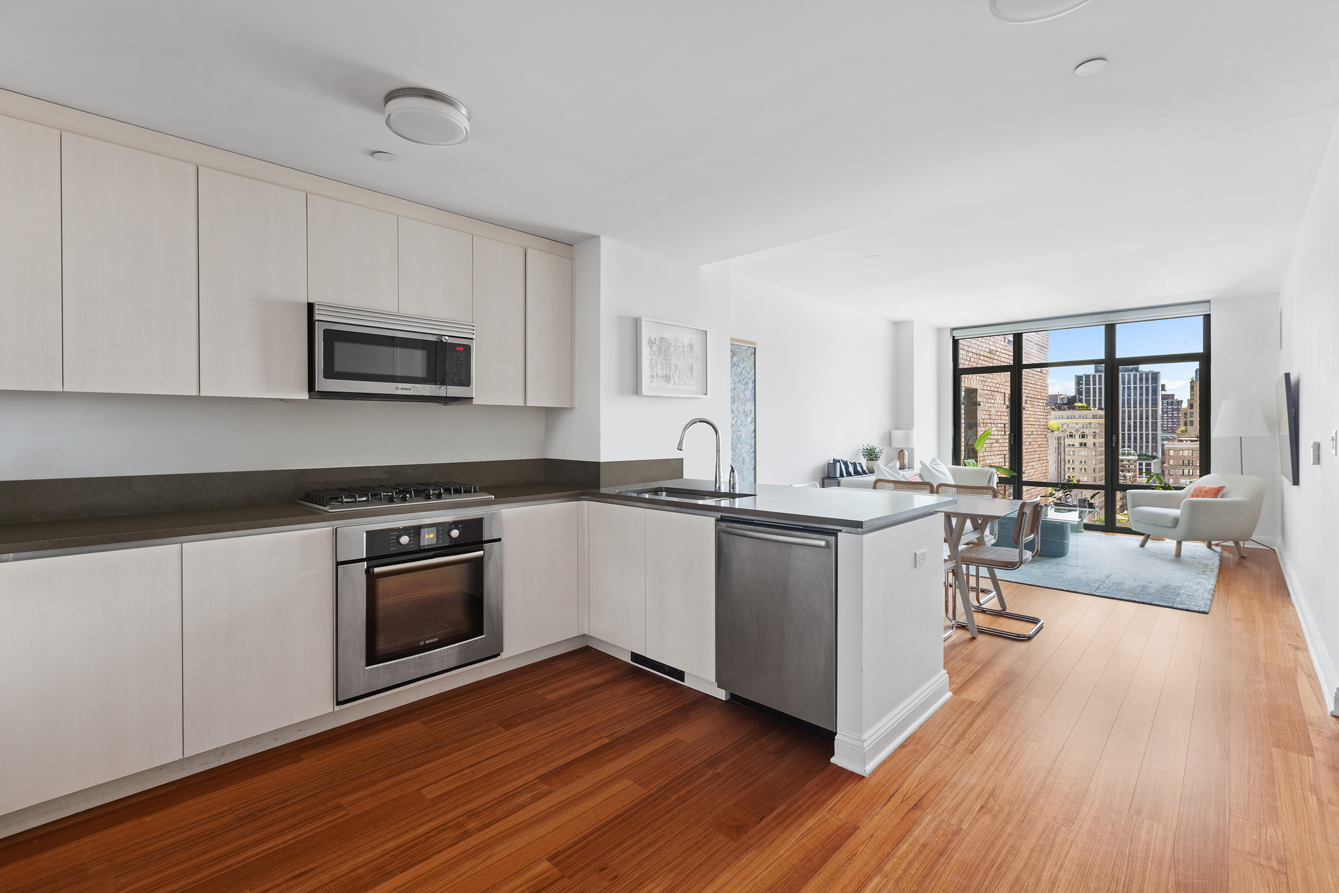 57 Reade Street, Unit 14C Manhattan, NY 10007 - Photo 6 of 16 a kitchen with wooden floors and stainless steel appliances