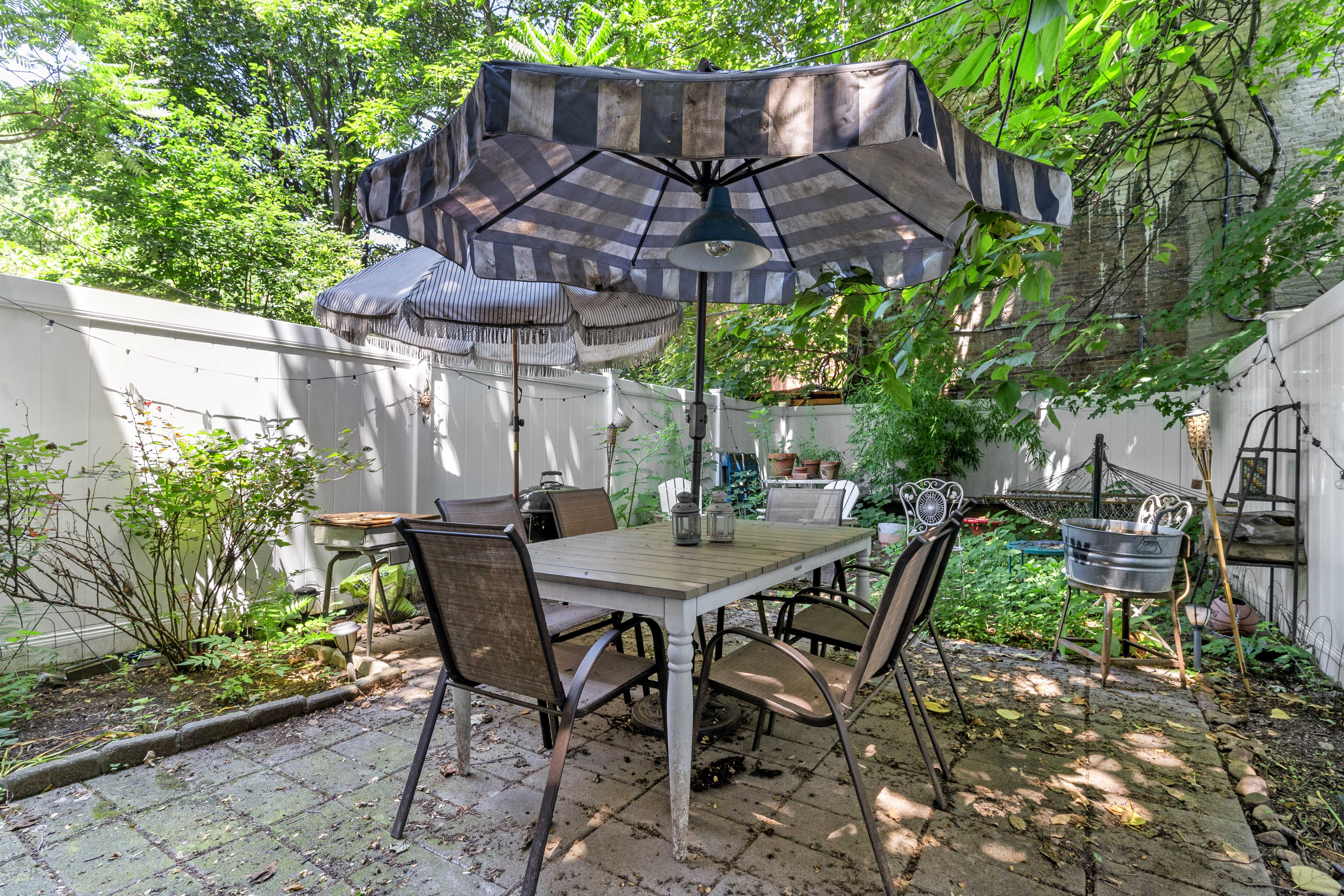 547 Gates Avenue, Unit 1 Brooklyn, NY 11216 - Photo 6 of 7 a view of patio with table and chairs potted plants and large tree
