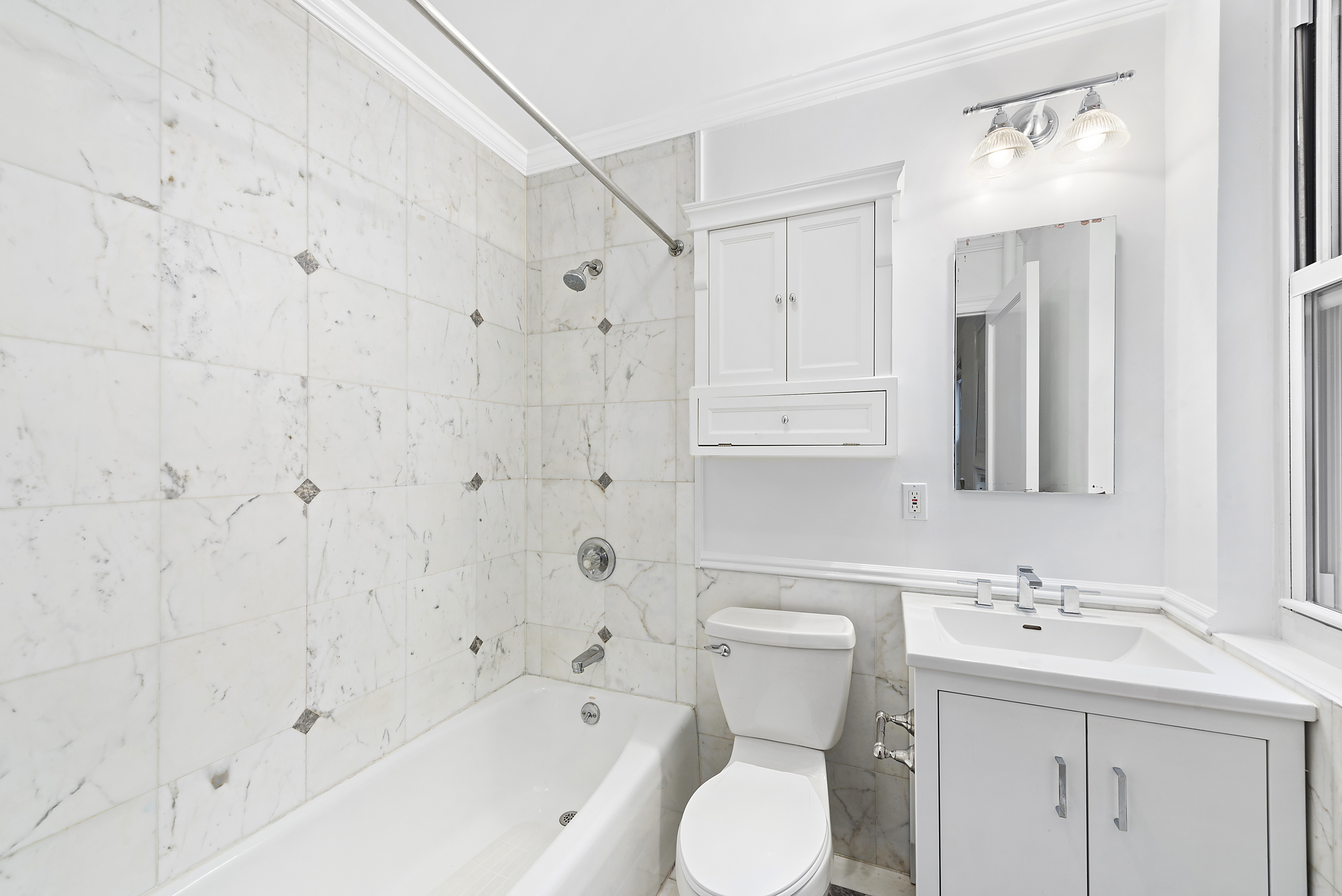 1240 Park Avenue, Unit 4C Manhattan, NY 10128 - Photo 4 of 9 a bathroom with a sink toilet and shower