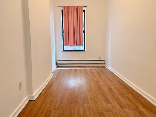 a view of a room with wooden floor and a window