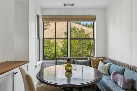 a dining room with furniture a window and a kitchen