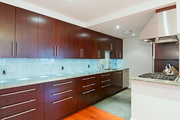 153 Stanton Street, Unit A1 Manhattan, NY 10002 - Photo 8 of 16 a kitchen with a sink and cabinets