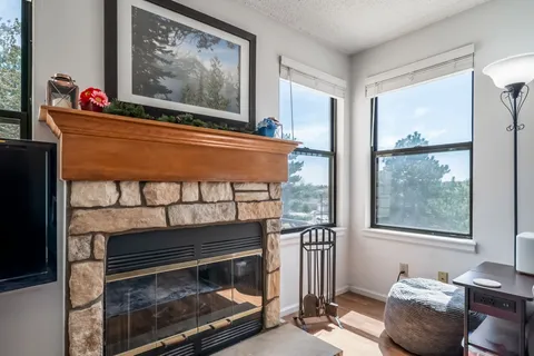 a living room with furniture a large window and a fireplace