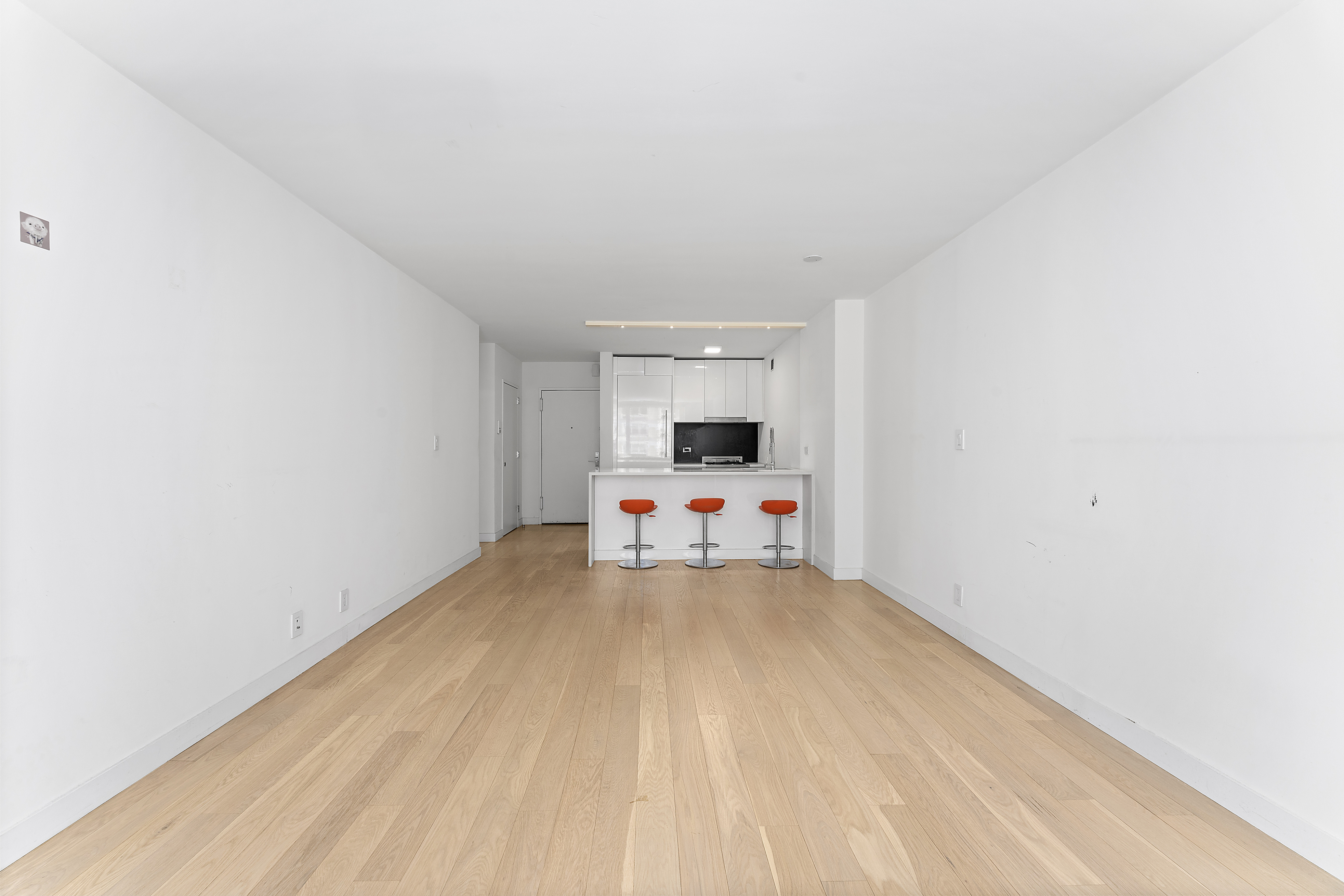 301 West 53rd Street, Unit 8J Manhattan, NY 10019 - Photo 5 of 14 a view of a room with wooden floor and white walls