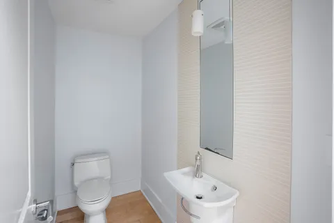 a bathroom with a toilet a sink and mirror