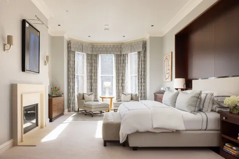 a spacious bedroom with a balcony a bed and a fireplace