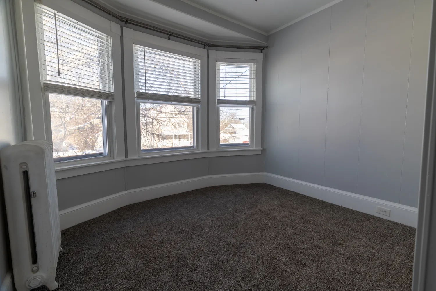 an empty room with windows and closet
