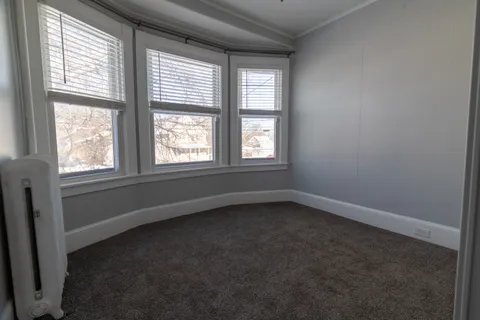 an empty room with windows and closet