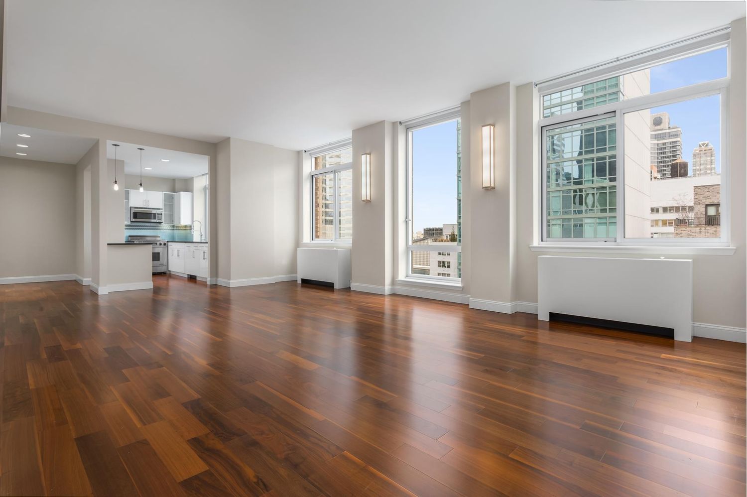212 East 57th Street, Unit 18A Manhattan, NY 10022 - Photo 2 of 14 a view of an empty room with a window and wooden floor