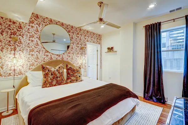 a bedroom with bed and a mirror