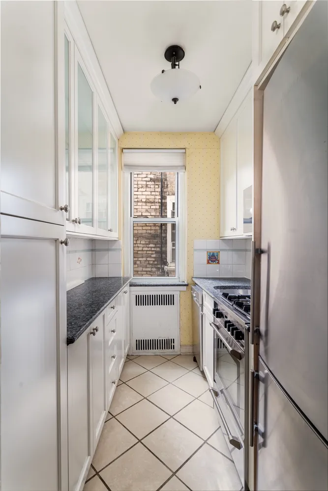 a kitchen with granite countertop a stove sink and cabinets