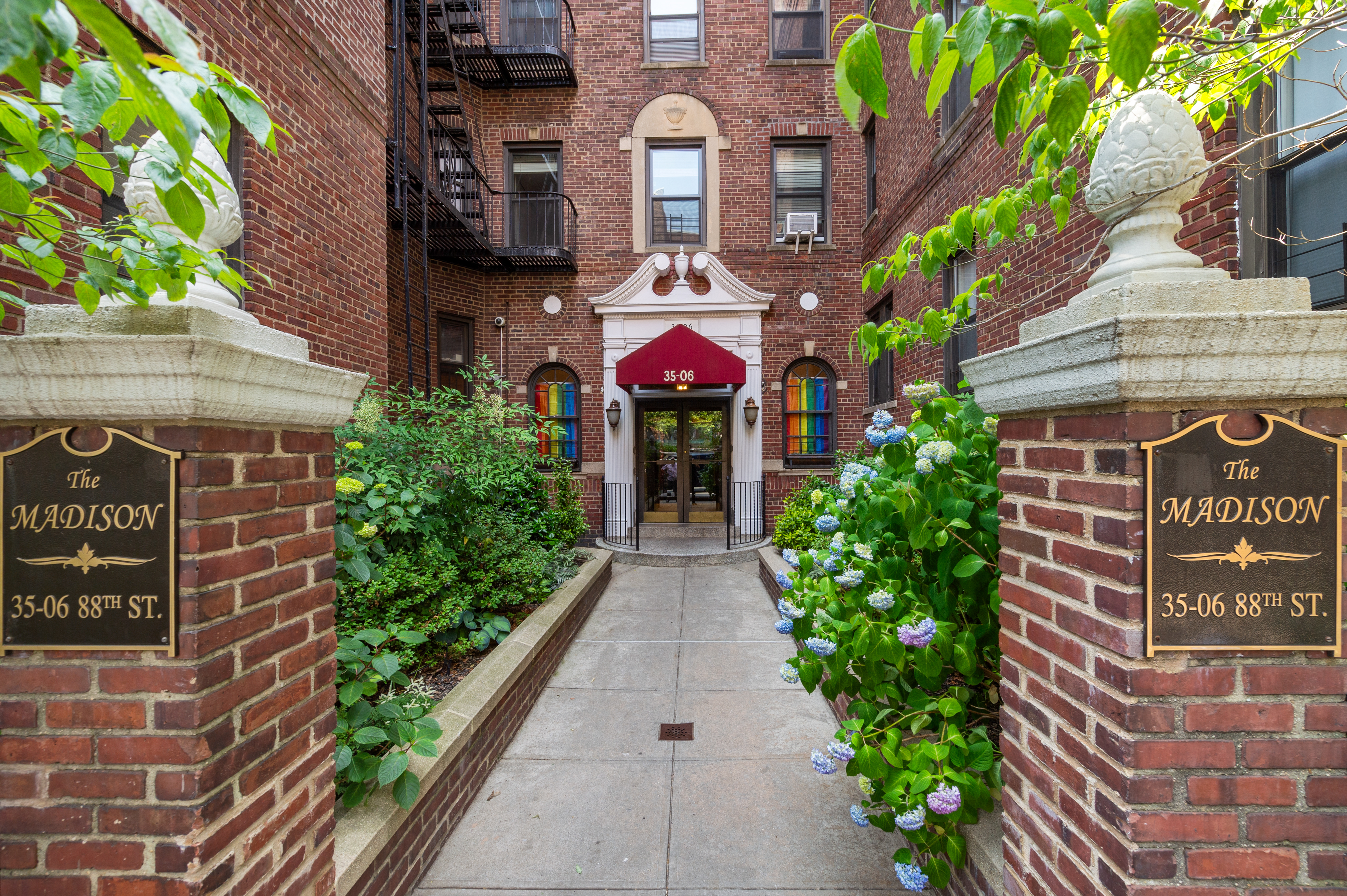 35-06 88th Street, Unit 6B Queens, NY 11372 - Photo 8 of 9 a front view of a multi story building with yard