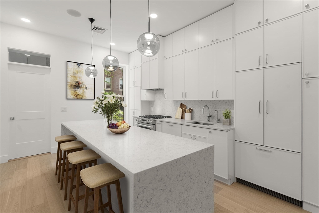 34 Worcester Square, Unit 2 Boston, MA 02118 - Photo 2 of 18 a kitchen with stainless steel appliances granite countertop a sink a refrigerator a stove a dining table and chairs