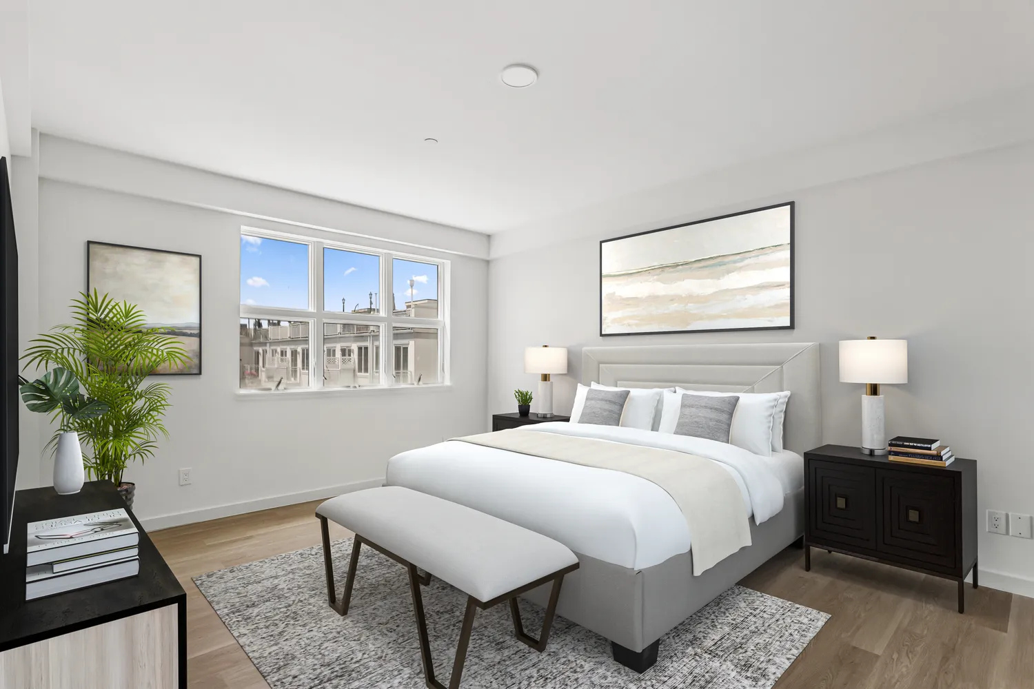a bedroom with a bed and a potted plant on the dresser