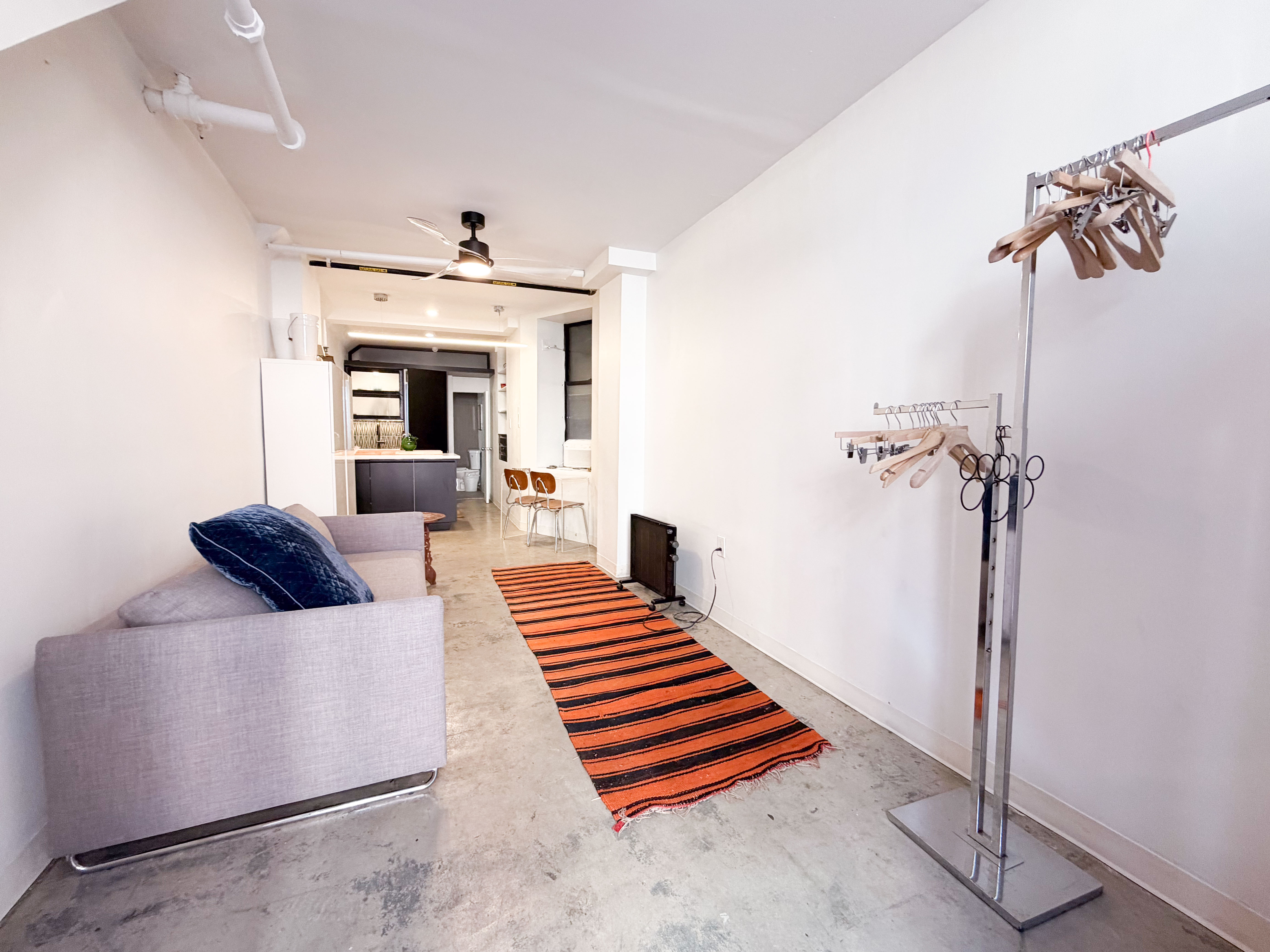 206 East 7th Street, Unit G Manhattan, NY 10009 - Photo 13 of 22 a hallway with a couch and a chandelier