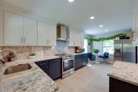 a kitchen with stainless steel appliances sink large window and cabinets