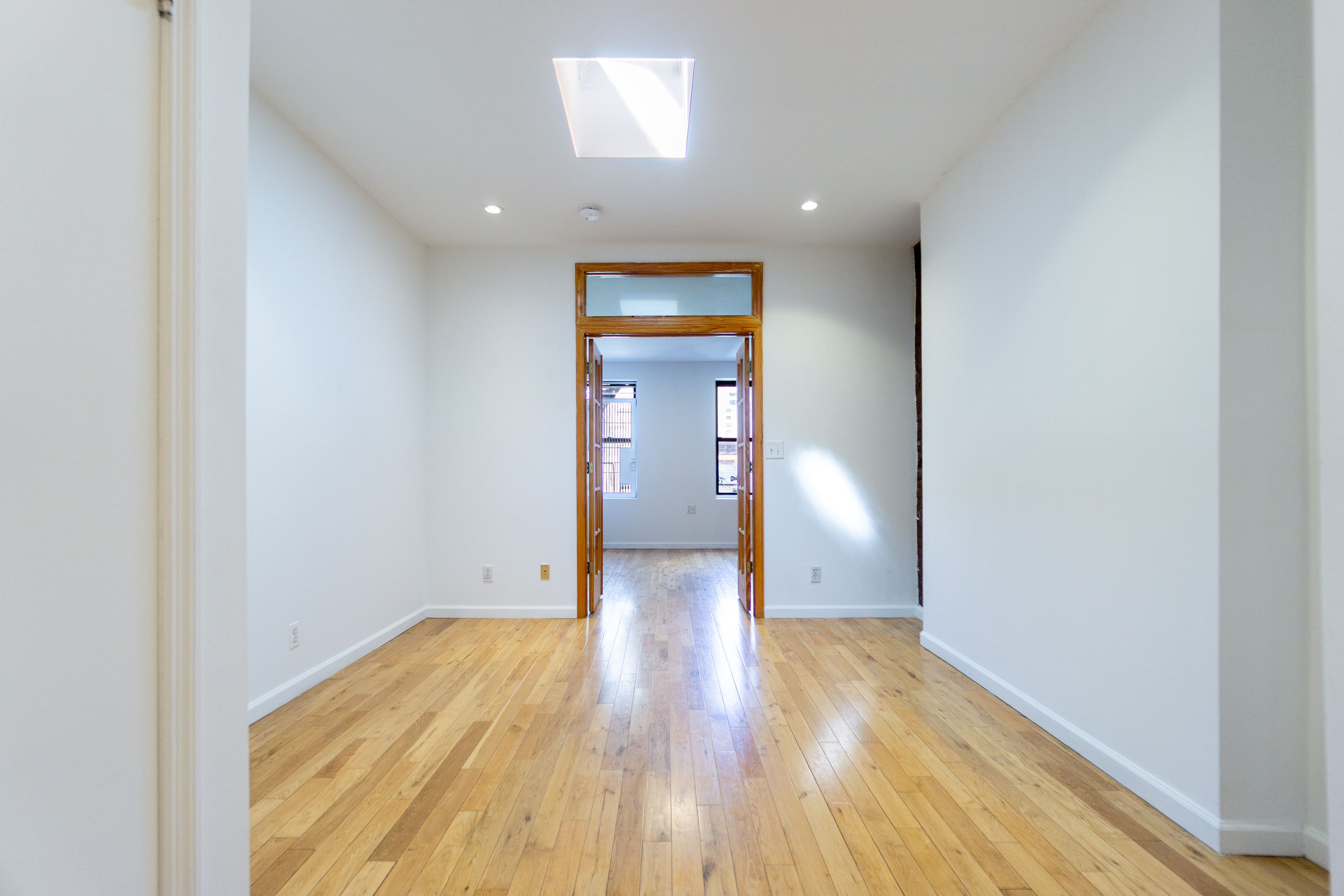 a view of empty room with wooden floor
