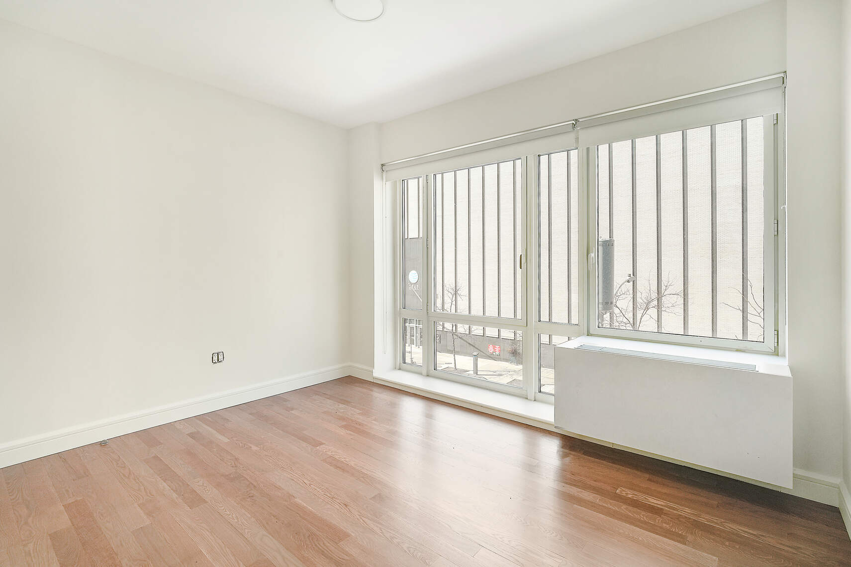 454 West 54th Street, Unit 3A Manhattan, NY 10019 - Photo 8 of 13 an empty room with wooden floor and windows