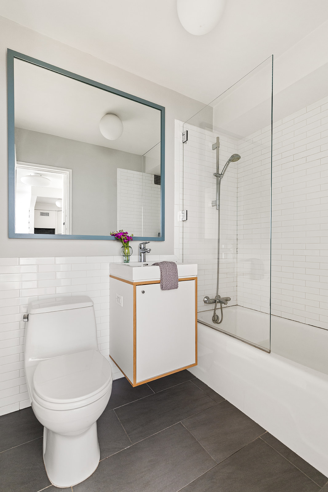 88 Bleecker Street, Unit 5G Manhattan, NY 10012 - Photo 5 of 9 a bathroom with a sink a toilet and a mirror