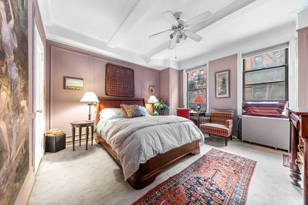 a bedroom with a bed couch and a window