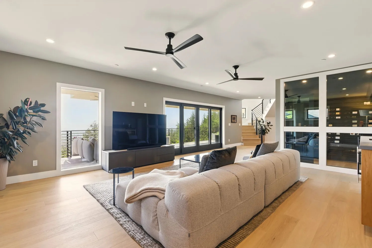a living room with furniture a flat screen tv and kitchen view
