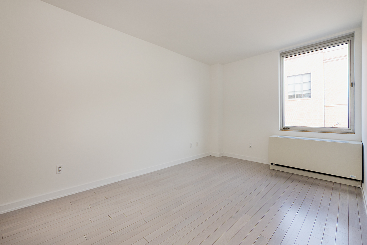 250 Bedford Avenue, Unit 129203 Brooklyn, NY 11249 - Photo 5 of 10 an empty room with wooden floor and windows