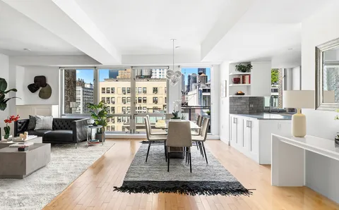 a living room with furniture a rug and white walls