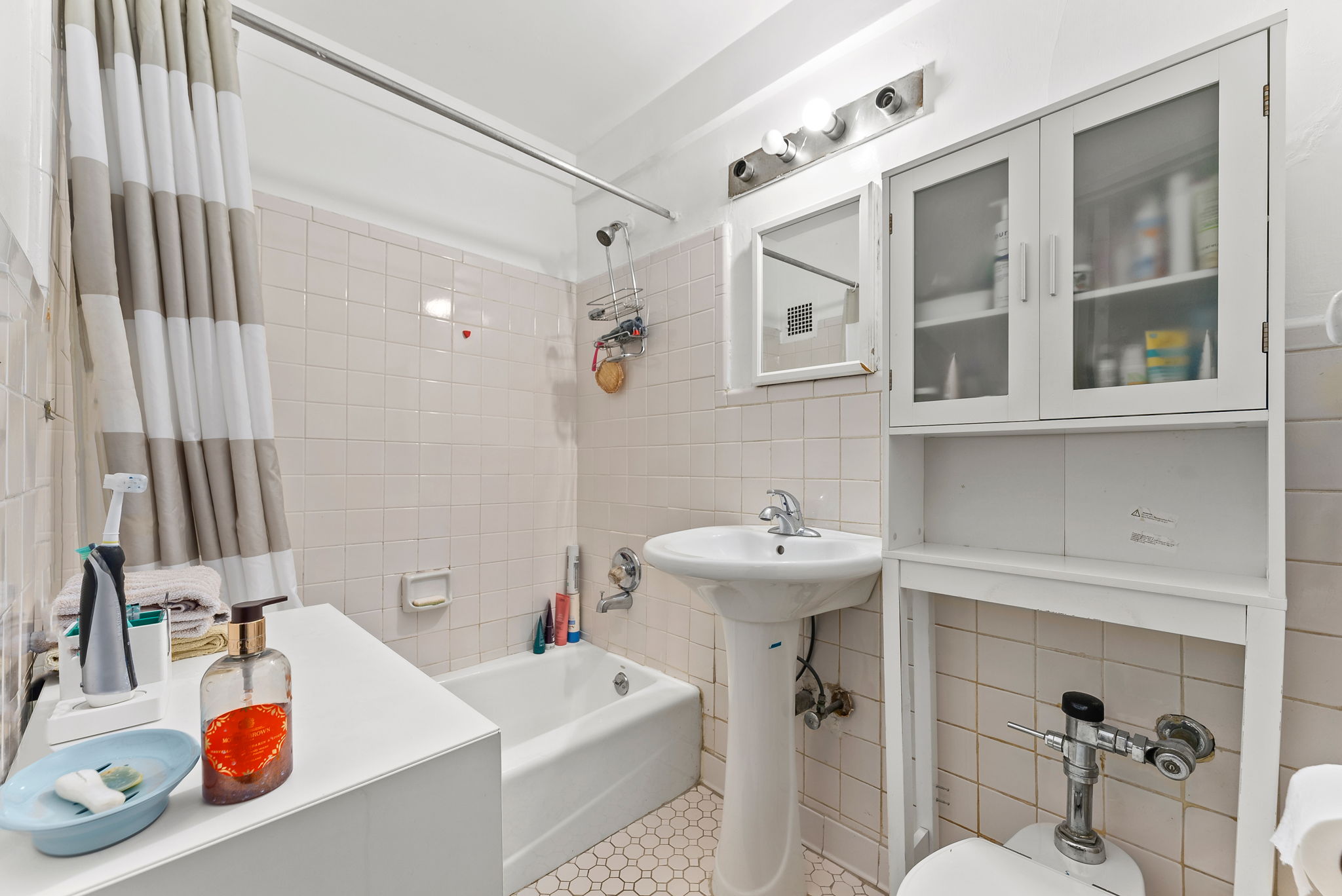 345 West 145th Street, Unit 11B2 Manhattan, NY 10031 - Photo 7 of 9 a bathroom with a sink and a mirror