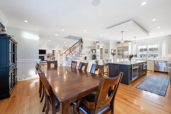 a dining room with stainless steel appliances kitchen island granite countertop a dining table chairs and a oven